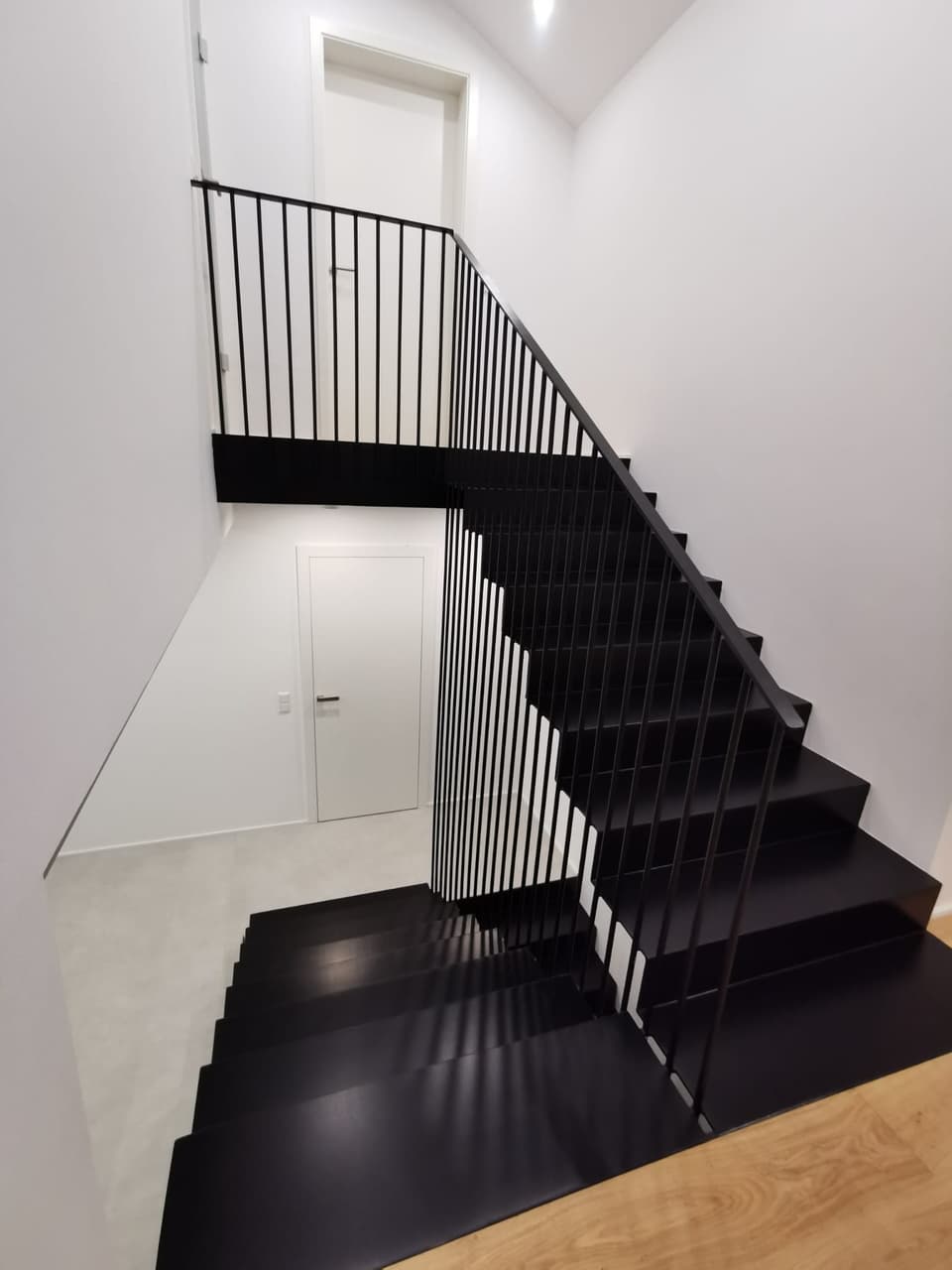 Moderne schwarze Metalltreppe mit Gelaender – Luft Metallbau